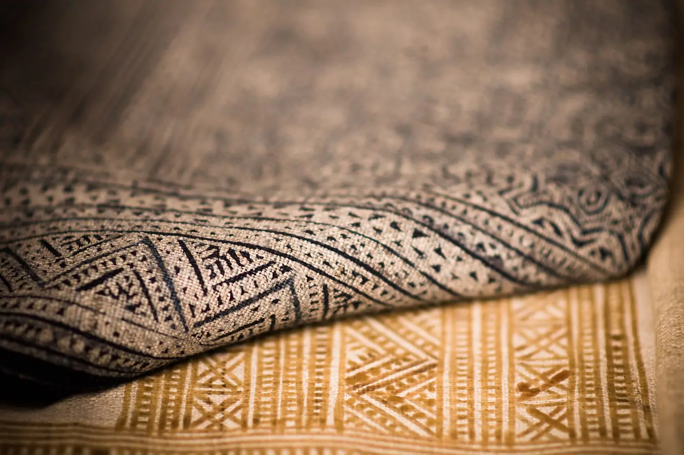Close-up of a patterned woven rug folded over another rug